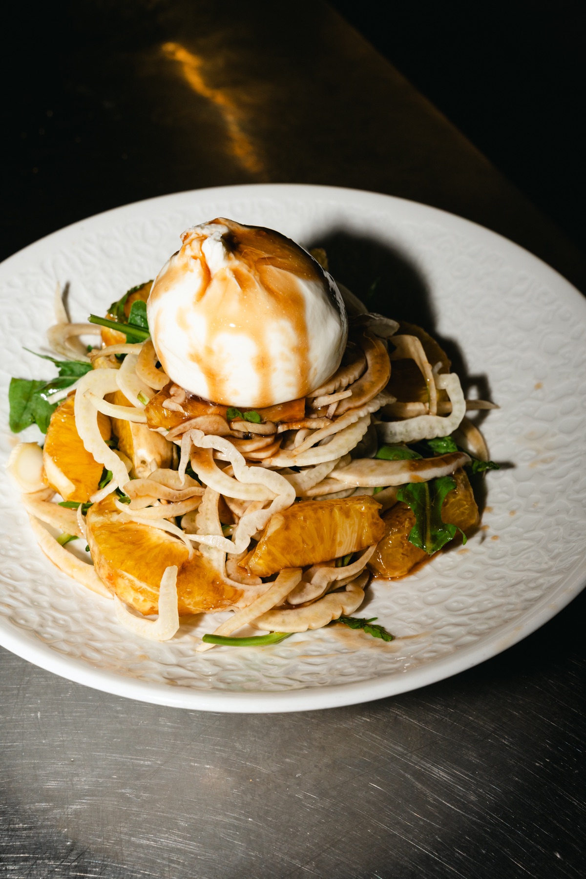 Vorspeise mit Burrata, Fenchel und Orangenfilets auf weißem Teller