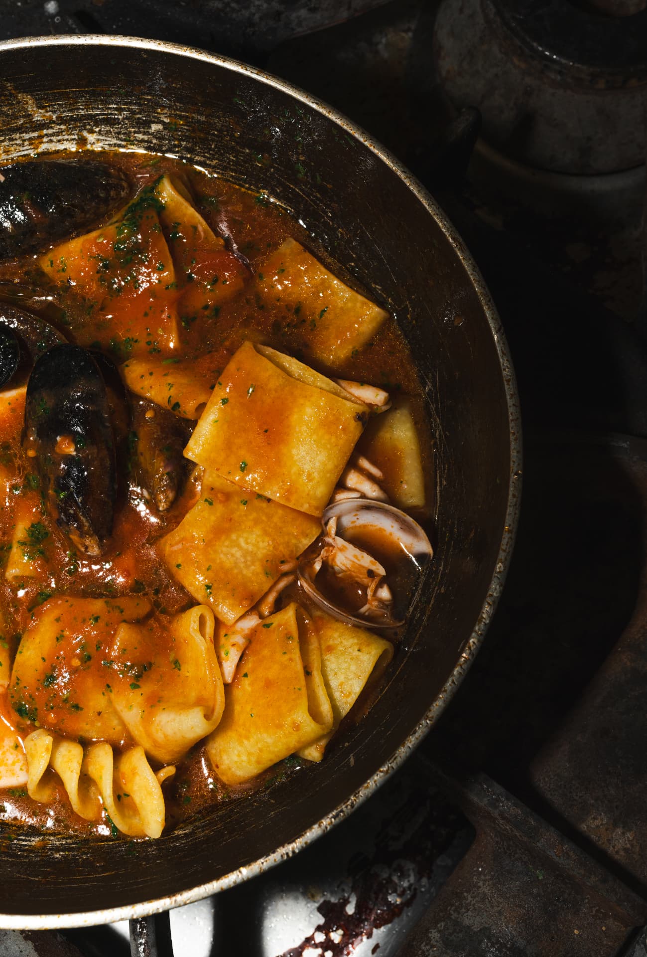 Pasta mit Muscheln in Tomatensauce in der Pfanne, von oben fotografiert